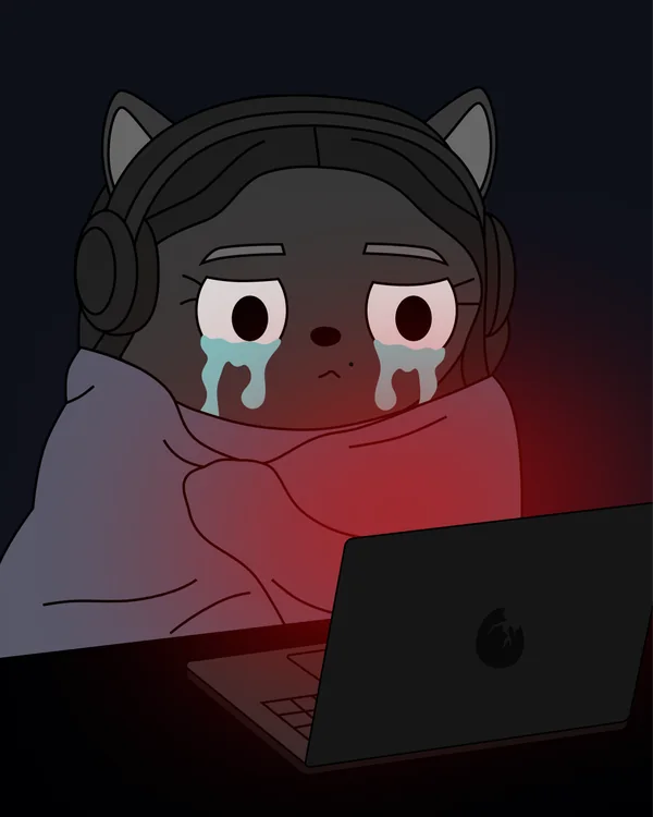 Momo in headphones crying under a blanket in front of a laptop